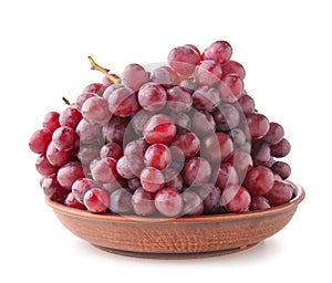 Plate with fresh grapes on white background