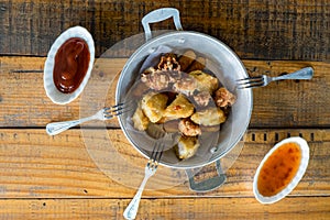 A plate of fresh, hot, crispy fried food on a wood table, fast food