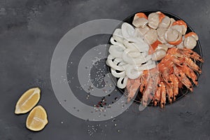 Plate of fresh mixed seafood isolated on gray background. Shrimp, squid rings, scallop