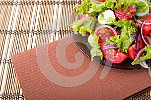 Plate with fresh salad of raw tomatoes and lettuce