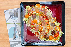 Plate of fresh salad with savoy cabbage, colorful tomatoes and peppers
