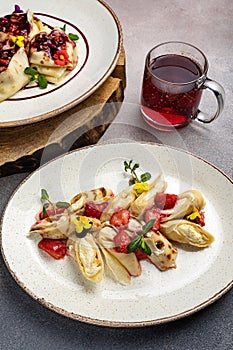 Plate of freshly made, mouth-watering pancakes topped with strawberries, with a filling