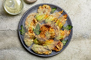 Plate with Fried in a batter Zucchini Flowers stuffed with ricotta cheese and parsley.