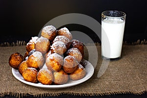 A plate of fried donuts and a glass of milk. Festive traditional Hanukkah food