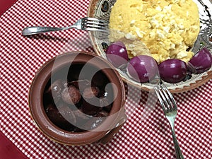 A plate of fried pork sausage, warm mamaliga with red onions