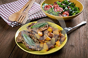 Plate with fried potatoes and vegetable salad