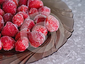 A plate with a frozen strawberries on it on the table