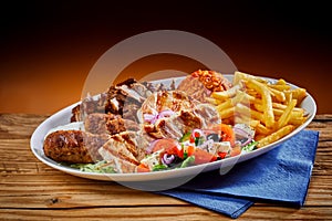Plate full of Greek cuisine souvlaki with fries