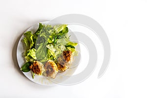 Plate of gourmet fried chicken with green fresh salad.