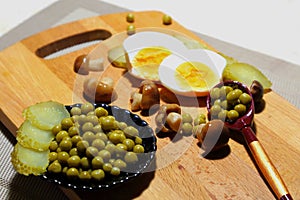 A plate of green peas with pickled cucumbers and mushrooms.