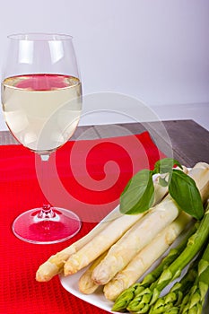Plate with green and white asparagus and wine