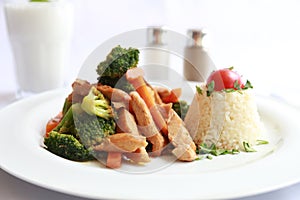 A plate with grilled chicken and vegetables and rice