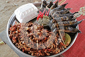 Plate of grilled crabs and fishes sold in a cambodian food market