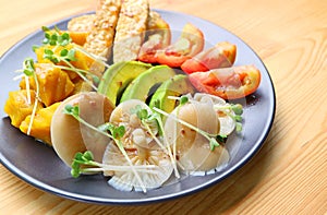 Plate of Grilled Oyster Mushrooms and Colorful Vegetables Salad Garnished with Daikon Microgreens