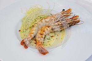 Plate of grilled prawns with sauce and vegetable sides