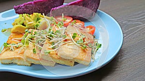 Plate of Grilled Tofu and Fresh Daikon Microgreens Salad with Purple Sweet Potatoes