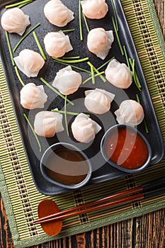 Plate of har gow dumplings, which is made a Chinese dumpling made of shrimp closeup on the table. Vertical top view