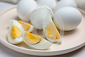 Plate with hard boiled eggs on white wooden table, closeup