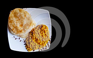 Plate having luchi and cholar dal gram gravy on a plate in black backgroundwith space for text