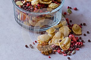 Plate of homemade muesli with cornflakes, freeze dried strawberry, walnuts, chocolate balls, pumpkin seeds