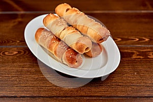 A plate of hot dogs sitting on top of a wooden table