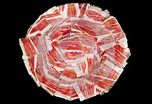 Plate of Iberian pork ham on black background photo