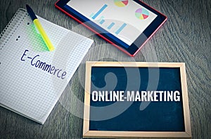 Plate with the inscription Online-Marketing andE-Commerce with a tablet Graphs and statistics and block to illustrate the increase