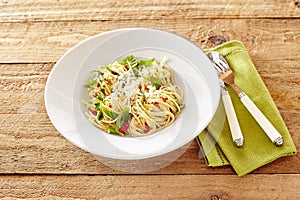 Plate of Italian spaghetti aglio olio with basil and tomato