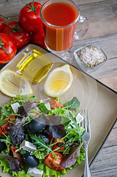 Plate with keto diet food. Chopped vegetables for the ketogenic diet on a plate. Tomatoes, salad with arugula, avocado and olives