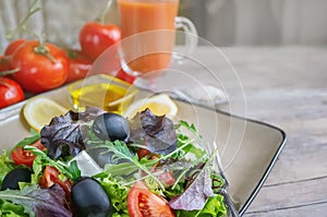 Plate with keto diet food. Chopped vegetables for the ketogenic diet on a plate. Tomatoes, salad with arugula, avocado and olives