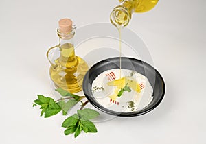 A plate of Labneh being poured with olive oil breakfast dish