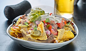 Plate of loaded nachos with queso cheese