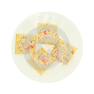 Plate of lobster dip on saltine crackers on white background