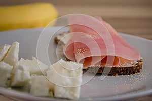 Plate of low-fat ham with spices on wholemeal bread and white cheese