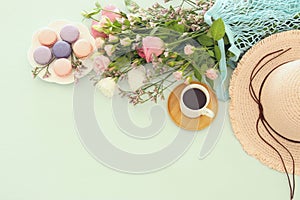 plate of macaroons over wooden table cofee and flowers.