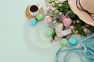 plate of macaroons over wooden table cofee and flowers.