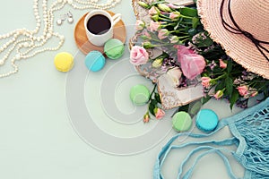 plate of macaroons over wooden table cofee and flowers.