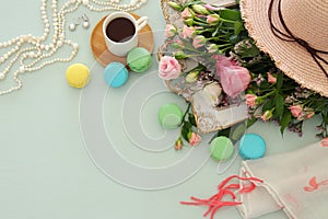 plate of macaroons over wooden table cofee and flowers.