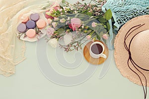 plate of macaroons over wooden table cofee and flowers.