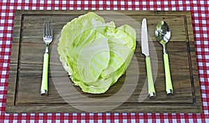 Plate made from cabbage and fork, knife and spoon beside