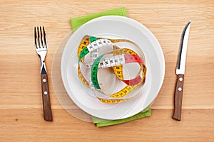 Plate with measure tape, knife and fork. Diet food