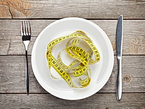 Plate with measure tape, knife and fork. Diet food