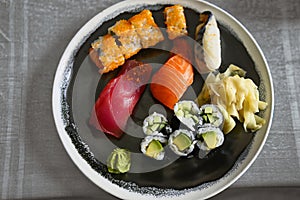 A plate of mixed sushi with wasabi and ginger