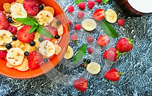 A plate of muesli with berries, banana and flax seeds is decorated with mint leaves. Healthy and healthy breakfast. Top view