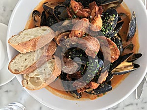 Plate of mussels in garlic sauce from top down