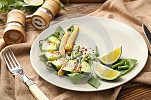 Plate with mussels and vegetables on table