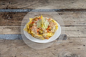 Plate of nachos with jalapenos in the zacatecas style with guacamole and pico de gallo