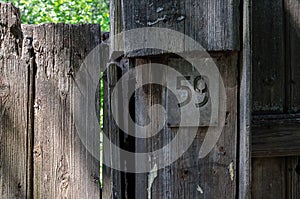 The plate number 59 on an old wooden fence