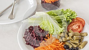 Plate of nutritious salad with lettuce, grated beetroot, carrot and cucumber