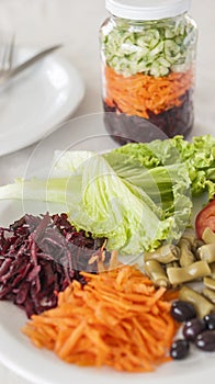 Plate of nutritious salad with lettuce, grated beetroot, carrot and cucumber